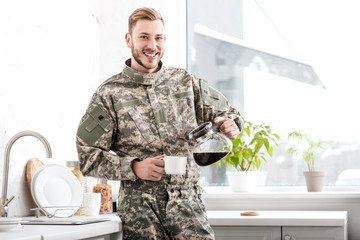 smiling army soldier pouring filtered coffee in kitchen