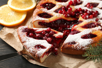 Tasty Christmas pie stuffed with cranberries on table