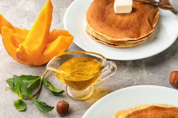 Plates with delicious pumpkin pancakes on table
