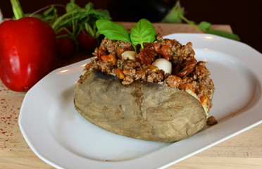 Kumpir - Traditional Turkish meal with baked potato, butter, cheese, bulgur salad, beef meat, mozzarella meat, tomato sauce and hot spices