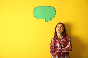 Thoughtful young woman near blank speech bubble on color background