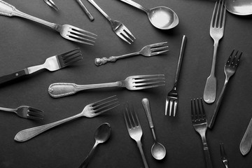 Spoons and forks on dark background