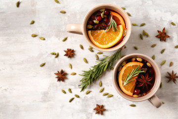 Cups of tasty mulled wine on light background