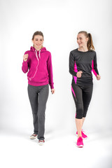 Two young attractive women in sports suits do morning jog