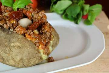 Kumpir - Traditional Turkish meal with baked potato, butter, cheese, bulgur salad, beef meat, mozzarella meat, tomato sauce and hot spices