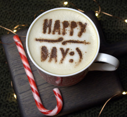 Cappuccino with happy day inscription and Christmas cane, top view
