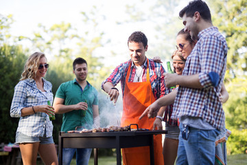 Friends enjoying bbq party and smiling in nature