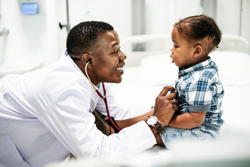 Cheerful pediatrician doing a medical checkup of a young boy - Powered by Adobe