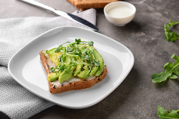 Tasty toast with avocado on plate