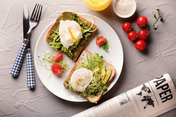 Fototapeta na wymiar Tasty toasts with avocado and eggs Benedict on plate