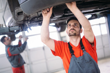 Car mechanics working at automotive service center