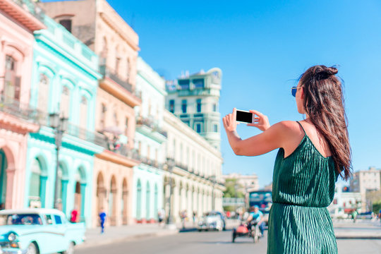 Tourist girl in popular area in Havana, Cuba. Young woman traveler smiling happy.