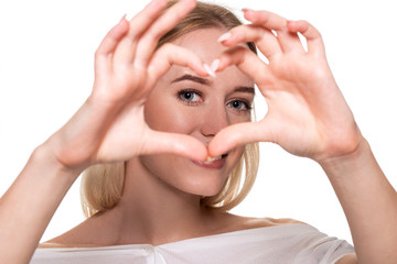 Portrait smiling young woman making heart sign with hands