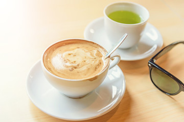 hot cappuccino coffee with green tea on table
