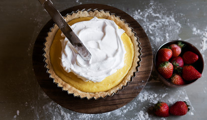 Chef spreading meringue to lemon tart