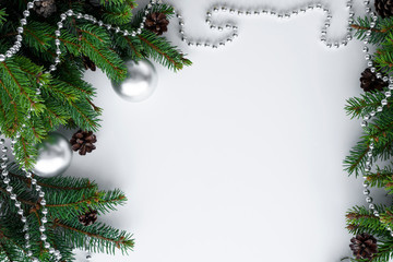 Beautiful christmas arrangement in silver and green colors style. Copy space for text, surrounded by green conifer branches, cones, baubles and chain.