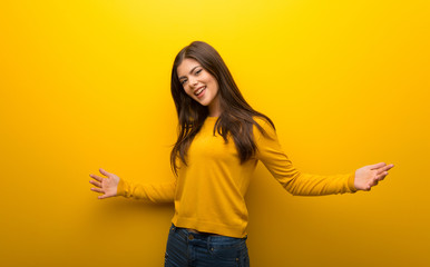 Teenager girl on vibrant yellow background proud and self-satisfied in love yourself concept