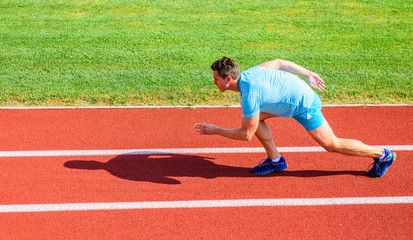 Boost speed concept. Man athlete runner push off starting position stadium path sunny day. Runner...
