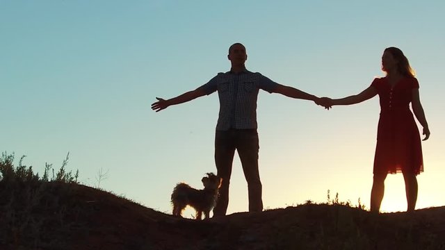 silhouette of a happy young married couple and dog slow dancing outside at sunset. slow motion video. man and girl dancing salsa at sunset. Unidentifiable Silhouette of dancing couple love friendship