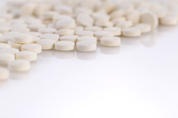 Close-up pile of white color medical pills on white background