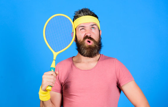 Athlete hold tennis racket in hand on blue background. Tennis club concept. Man bearded hipster wear old school sport outfit with bandages. Tennis player retro fashion. Tennis sport and entertainment