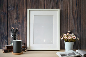 Mockup white poster with home office supplies over wooden wall.