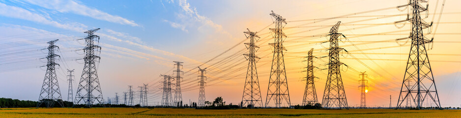 high-voltage power lines at sunset,high voltage electric transmission tower - obrazy, fototapety, plakaty