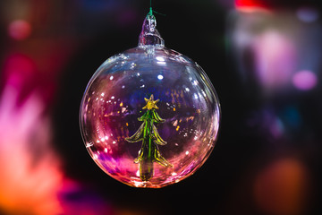 Suspended opaque glass christmas ball against a blurred background