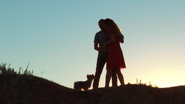 silhouette of a happy young married couple and dog slow dancing outside at sunset. slow motion video. man and girl dancing salsa at sunset. Unidentifiable Silhouette of dancing lifestyle couple love