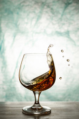 Cognac in a glass goblet with splashes