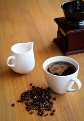 Aromatic fresh coffee in porcelain cup on wooden table