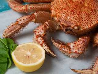 Whole boiled crab with lemon and greens.