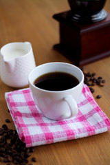 Aromatic fresh coffee in porcelain cup on wooden table
