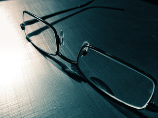 glasses on a dark background, shadow of the rim, metallic material