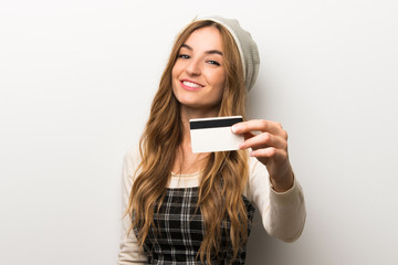 Fototapeta premium Fashionably woman wearing hat holding a credit card