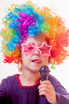 The famous actress. Humorous photo of cute child girl singing with a microphone. Happy childhood, teaching singing, music, child development concept.