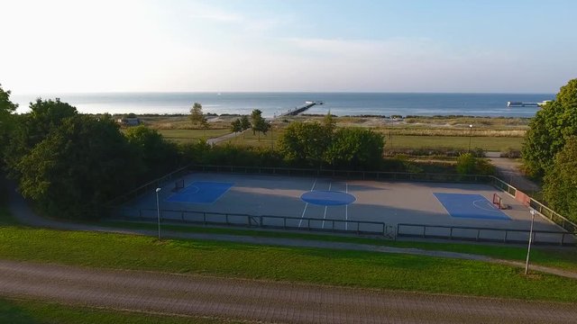 Dolly shot of Malmoe beach and a pier with a mini soccer court in 4k.