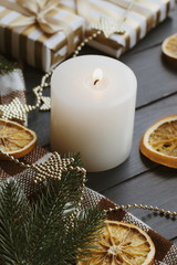 Christmas background with gift boxes  oranges  burning candle on the table. Golden decor for xmas.