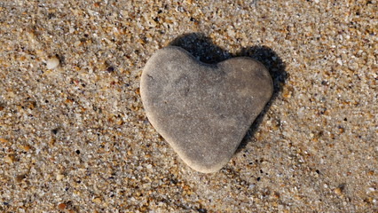 Stone in the form of a heart in the sand, as a symbol of love.