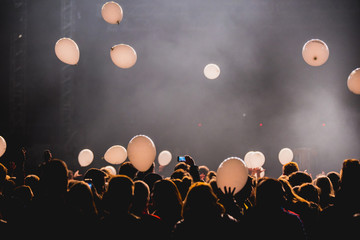 Fototapeta na wymiar Crowd at concert, balloons in the air.