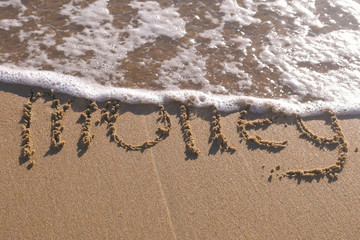 Word Summer written in the sea sand. Waves washed away the inscription.