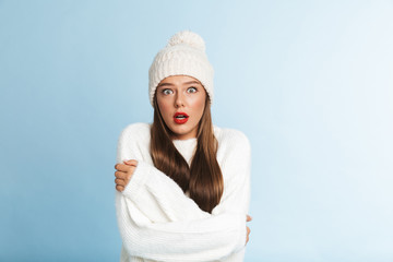 Obraz premium Frozen young woman wearing hat and sweater standing