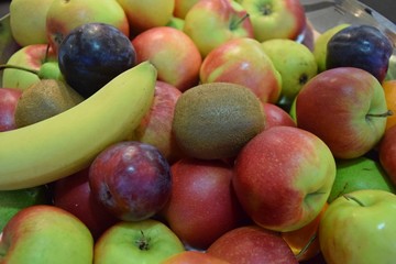 Früchtekorb mit reifen Äpfeln, Bananen, Pflaumen und Kiwis