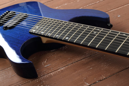 Musical instrument - Fragment blue electric guitar solid-body on a wood background