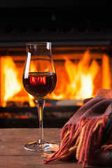 glass of cognac in front of fireplace