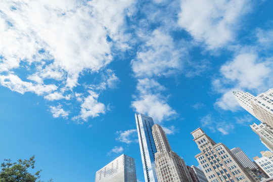 Look up view of typical skyline office building in Chicago downtown against cloud blue sky
