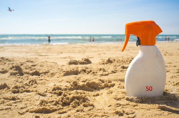 Sunblock cream with Sun Protection Factor or SPF 50 on beach sand