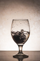 Falling a plum in cold water in a glass with splashes