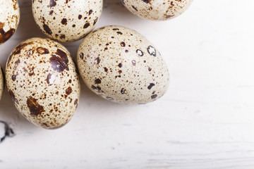 quail eggs on a white wooden background.