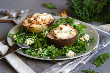 Baked pears with gorgonzola, chicken, walnuts and mozzarella with arugula on a grey plate. Grey slate, stone or concrete table. Healthy salad or snack for Christmas or New Year. Copy space.